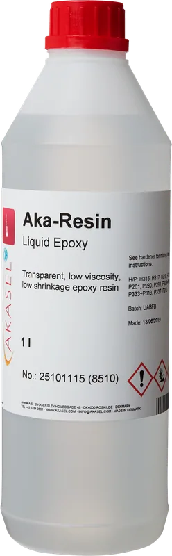 En 1-liters flaska transparent epoxiharts med röd kork. Etiketten visar ”Aka-Resin Liquid Epoxy,” ”Transparent, low viscosity, low shrinkage epoxy resin,” samt ytterligare blandningsinstruktioner och säkerhetsinformation. Artikelnumret 25101115 (8510) och produktionsdatumet är också synliga. Speciellt utvecklad för metallografiska applikationer, idealisk för att skapa precisa och stabila provhållare för analys.